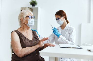 Beyaz önlüklü hemşire, silah dokunulmazlığı koruma pasaportuda iğne yapıyor.