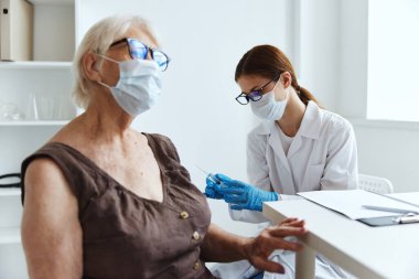 Yaşlı kadın aşı pasaportu için kadın doktor aşısı.
