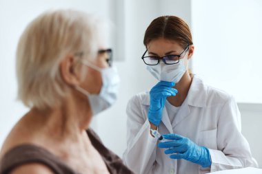 Doktorun yanındaki yaşlı kadın pasaport.