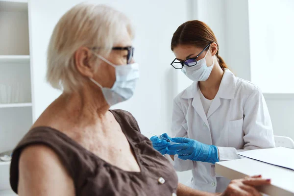 의사 백신 여권 옆에 의료용 마스크를 쓰고 있는 할머니 — 스톡 사진