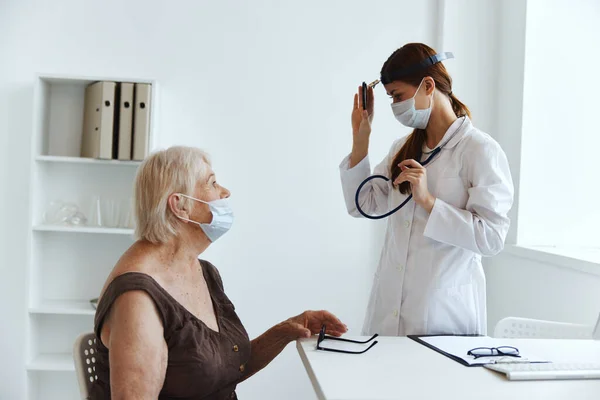 간호사의 건강 진단에 의해 검진을 받기 위해 의료용 마스크를 쓰고 있는 노인 — 스톡 사진