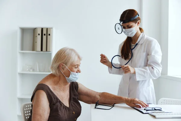 Äldre kvinna patient vid läkare stetoskop — Stockfoto