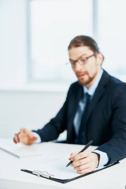 Masa başında takım elbiseli bir adam çalışıyor.