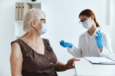 Kadın doktor, kol bağışıklık aşısı güvenlik aşısı pasaportuna enjeksiyon yapıyor.