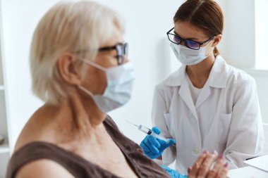 Kadın doktor şırınga enjeksiyonu aşı pasaport hastanesi