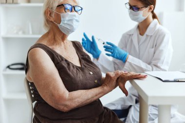 Şırıngalı bir doktor kol aşısı pasaportuna iğne yapıyor.