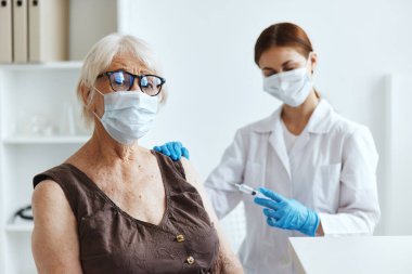 Kadın doktor, kol aşısı pasaportuna enjeksiyon yapıyor.