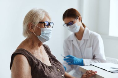 Yaşlı kadın hasta, doktorun pasaportunun yanında.