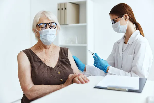 Elderly woman patient sitting next to the nurse vaccine passport — Stock Photo, Image