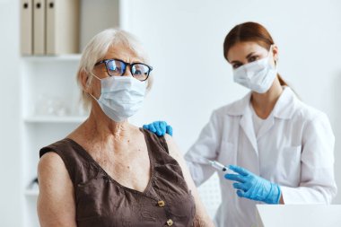 Şırıngalı bir doktor kol aşısı pasaportuna iğne yapıyor.