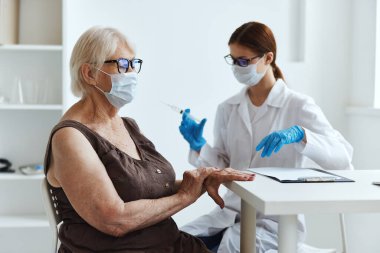Kadın doktor, kol aşısı pasaportuna enjeksiyon yapıyor.