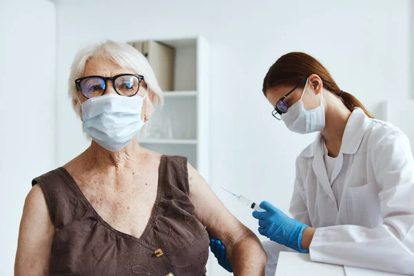 Anciana con máscara médica junto a la protección de inmunidad del médico — Foto de Stock