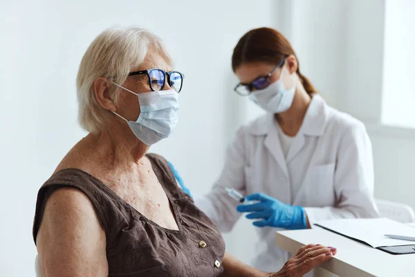 高齢者医療のマスク看護師の予防接種 — ストック写真