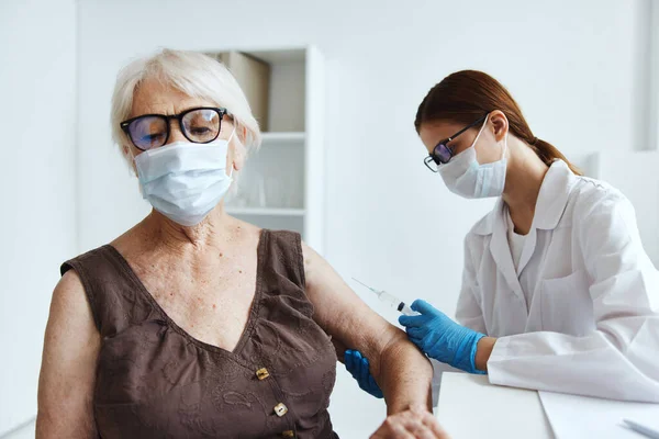 Paziente anziana accanto al medico protezione immunitaria — Foto Stock
