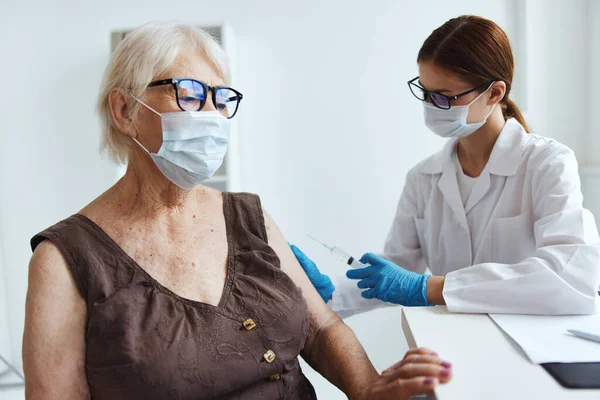 高齢女性ワクチンパスポートの白衣予防接種看護師 — ストック写真