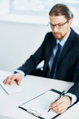 Takım elbiseli bir işadamı masa başı evrakları ofisinde çalışıyor.