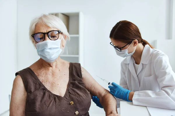 Femme âgée portant un masque médical à côté de la protection de l'immunité du médecin — Photo