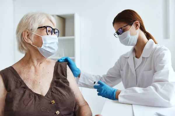 Maschera medica infermiere vaccinazione di una donna anziana immunizzazione vaccino di sicurezza passaporto — Foto Stock
