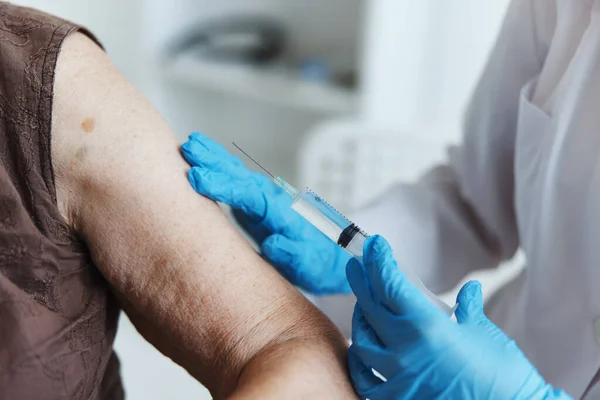 Läkare gör en injektion i armen covid-19 pass närbild — Stockfoto
