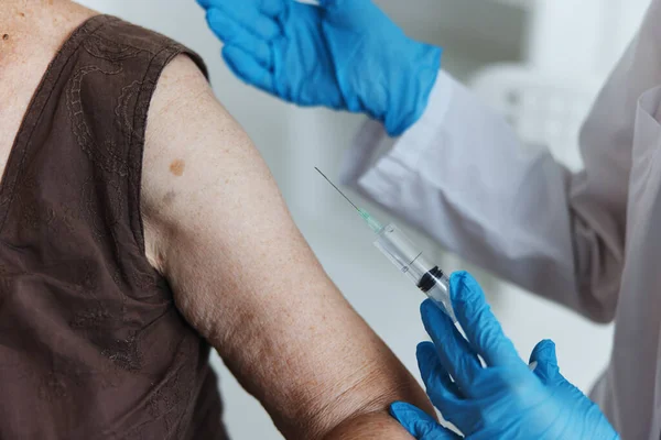 Pielęgniarka wykonuje wstrzyknięcie w paszport szczepionki na ramię zbliżenie — Zdjęcie stockowe