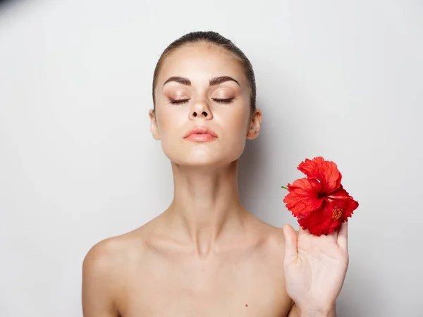 Atractiva mujer con hombros desnudos sosteniendo una flor roja en su mano —  Fotos de Stock
