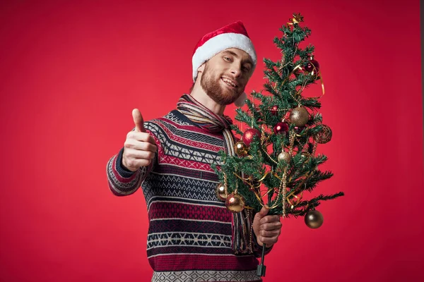 Noel Baba şapkalı yakışıklı adam Noel süsleri Noel stüdyosunda poz veriyor. — Stok fotoğraf