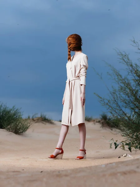 Mujer de abrigo blanco en la arena de la playa posando aire fresco —  Fotos de Stock
