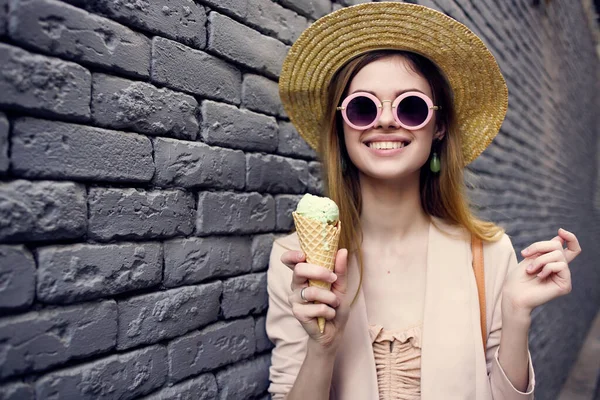 Vrolijk vrouw dragen zonnebril baksteen muur lopen ijs — Stockfoto