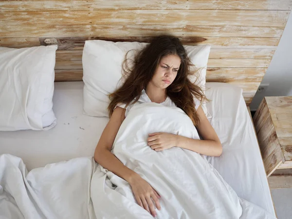 Грустная женщина с надутыми губами лежит в постели утром недовольство — стоковое фото