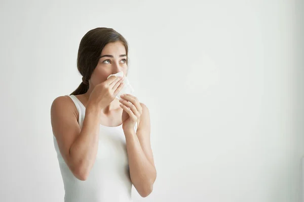 Γυναίκα με λευκό μπλουζάκι φυσάει τη μύτη της σε λοίμωξη από κρύες μαντίλες — Φωτογραφία Αρχείου