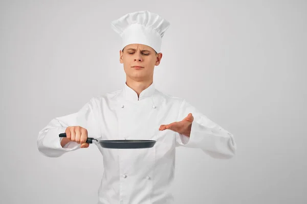 Mężczyzna w kucharzy mundur patelnia w ręce gotowanie żywności w kuchni — Zdjęcie stockowe