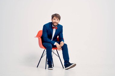 Stüdyoda sandalyede oturan takım elbiseli bir iş adamı. 