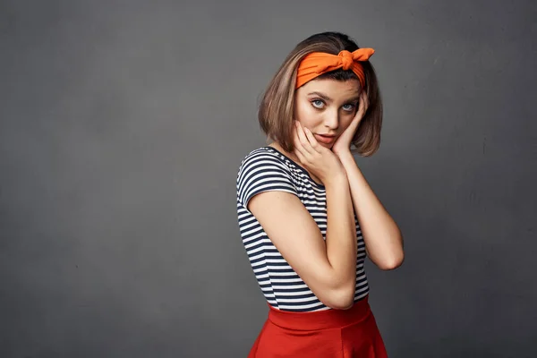 Jolie femme à la mode avec bandeau orange jupe rouge posant — Photo