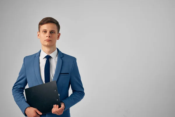 Homme dans un costume avec des documents dans ses mains fond de lumière de bureau professionnel — Photo