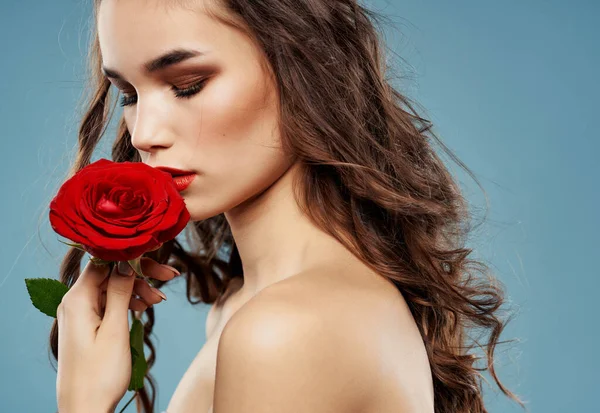 Brunetka jasný make-up růže v ruce luxusní modré pozadí — Stock fotografie