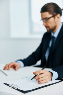 Takım elbiseli bir işadamı masa başı evrakları ofisinde çalışıyor.