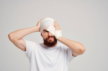 Kafası bandajlı ve arka planda kan izole edilmiş bir hasta.