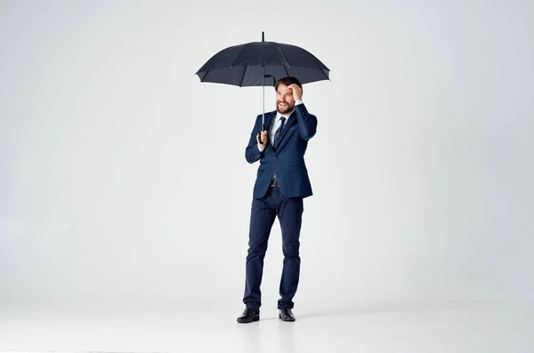 Homem de negócios em um terno segurando um guarda-chuva estilo elegante proteção contra chuva — Fotografia de Stock
