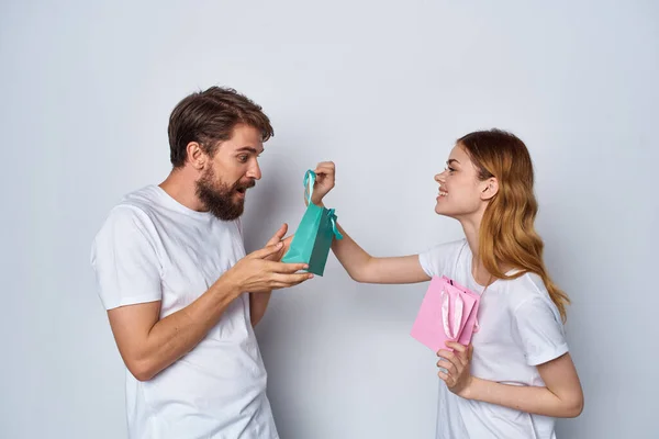 Νεαρό ζευγάρι σε λευκό t-shirts δώρα διασκέδαση συναισθήματα διακοπές — Φωτογραφία Αρχείου