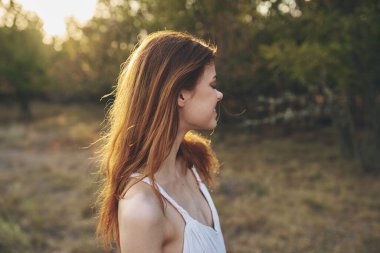 Beyaz elbiseli güzel bir kadın yaz aylarında temiz hava alıyor.