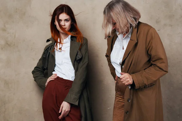 Joven y anciana están de pie uno al lado del otro en un abrigo posando — Foto de Stock