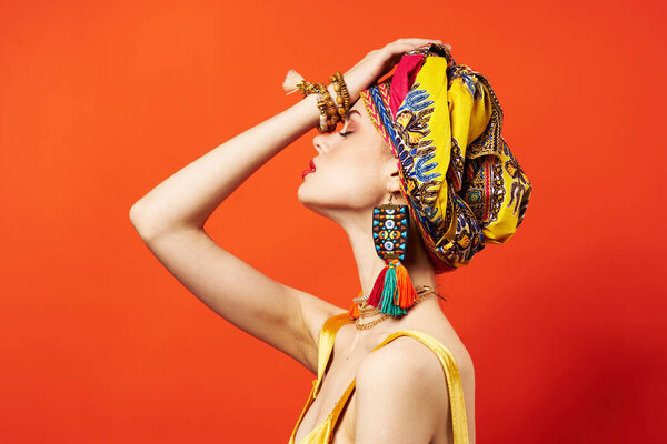 beautiful woman ethnicity multicolored headscarf makeup glamor red background