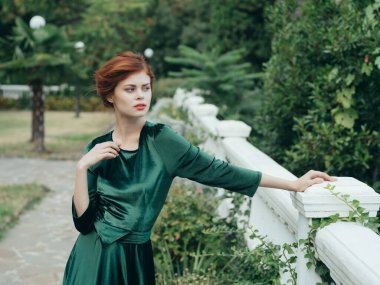 Yeşil elbiseli kadın. Parkta romantik bir yürüyüş.