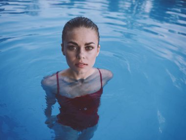 Havuzda güzel bir kadın yüzüyor, dinleniyor, manzarası çok güzel.