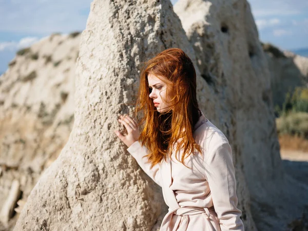 Mulher posando perto de rochas na areia olhar atraente — Fotografia de Stock