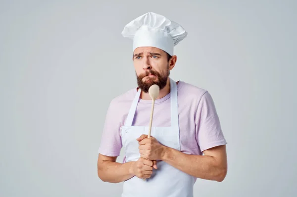 Uno chef con un cucchiaio di legno nelle mani di un servizio di ristorazione professionale — Foto Stock