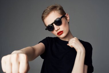 Kısa saçlı kadın el hareketi. Kırmızı dudaklar koyu arkaplan.