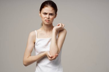 Beyaz tişörtlü kadın romatizması dirsek ağrısı sağlık sorunları hafif arka plan