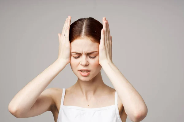 Donna in t-shirt bianca mal di testa problemi di salute stress isolato sfondo — Foto Stock