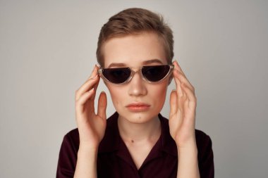 Kısa saç gözlüğü stüdyosunda poz veren şık bir kadın.